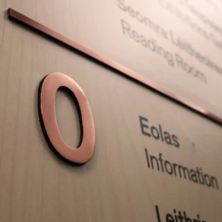 Close up of copper number 0 on a wayfinding board.