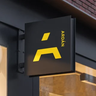 Closeup of a sign protruding from a building with the Ardán logo.