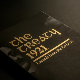 Cover of the book 'The Trety 1921 – Records from the Archives'. The title is set in a gold foil with black and whote images of Arthur Griffith and David Lloyd George either side of the title.