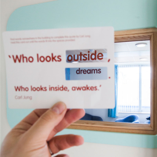 A card held up in front of the window, that combines to make the phrase 