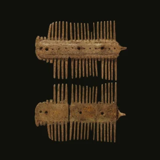 Early medieval bone comb artifact displayed against a dark background