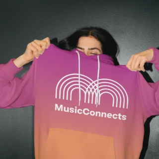 Person holding up a purple and orange gradient hoodie with the Music Connects logo