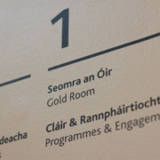 Close-up detail of white vinyl lettering applied to a dark wall surface showing the signage typography