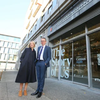 Two people stand in front of a large blue wall display titled ‘The Story of Us – Census 1926’ at the National Archives of Ireland, discussing the exhibition.