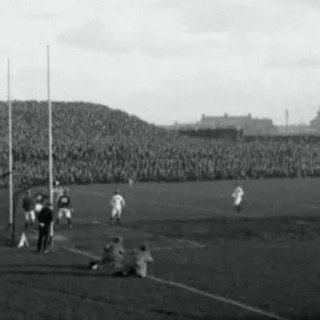 Black and white photograph of a Gaelic football match at Croke Park, 1926, with a packed terrace of spectators visible in the background.