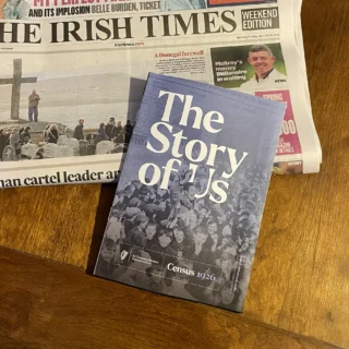 The Story of Us Census 1926 newspaper booklet resting on top of the Irish Times Weekend Edition, dated Saturday/Sunday 18/19 April 2026, photographed on a wooden table.