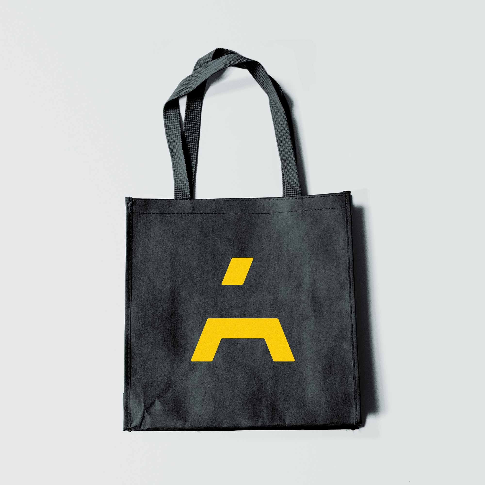 Tote bag with large yellow A symbol on a black cotton